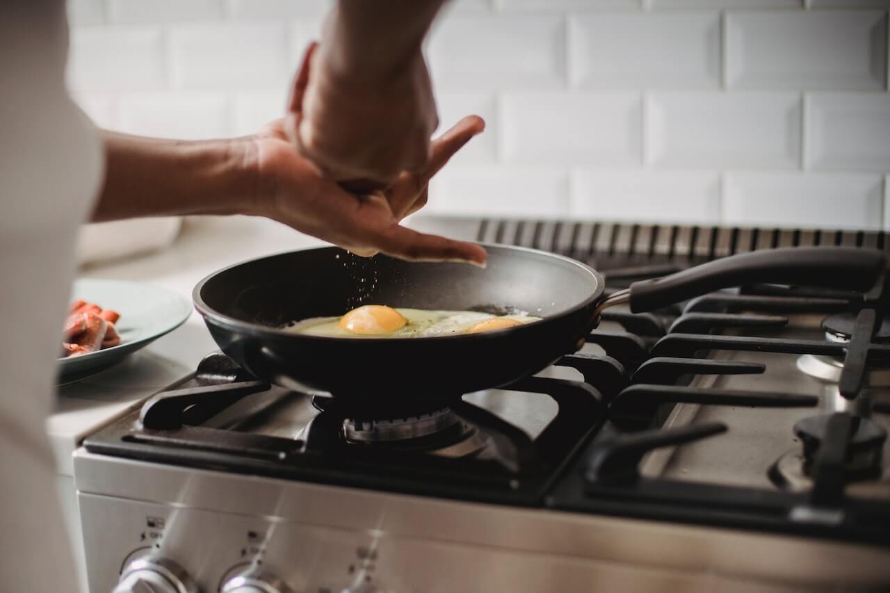 La photo d'une personne faisant frire un œuf